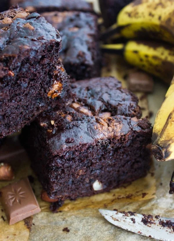 Chocolate Banana Chocolate Chip Cake cut into squares and stacked on top of each other whimsically