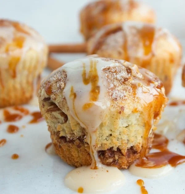 side view of Cinnamon Rolls Muffin drizzled with cream cheese and caramel icing