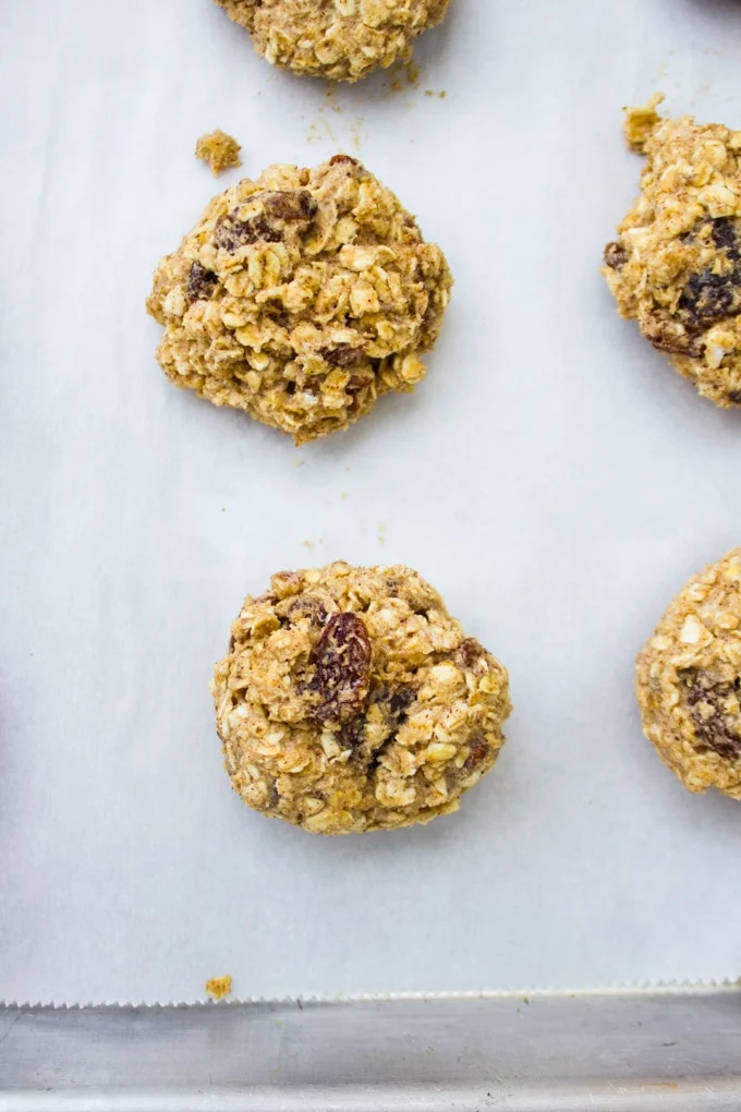 scooped out cookie batters balls into a baking sheet ready to bake into healthy oatmeal raisin cookies