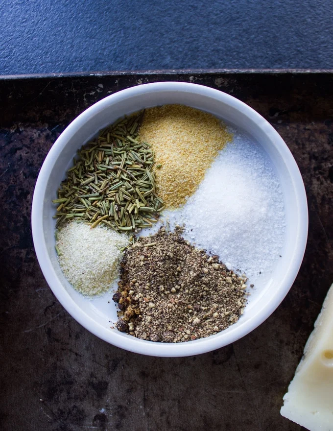 A small plate with the burger seasoning including salt, pepper, garlic powder, garlic powder and dried rosemary