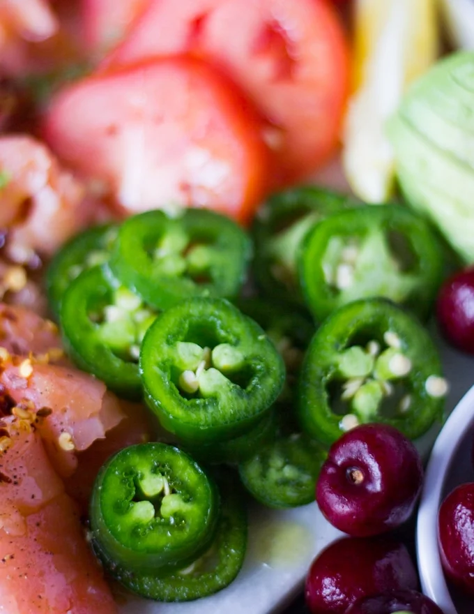 close up sliced jalapenos on the smoked slamon platter