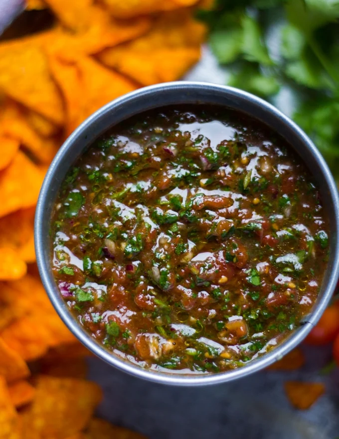 close up of the salsa top view shoing the chunky texture of ingredients and a thin layer of oil for storing and extending freshness