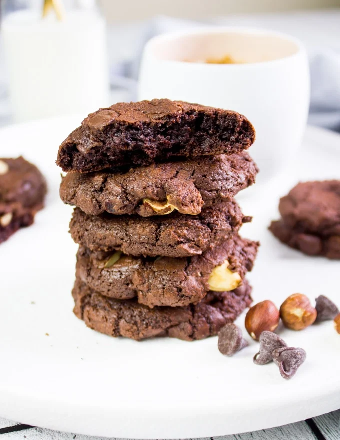 5 Piled up brownie cookies close up and the top one is bitten to show texture
