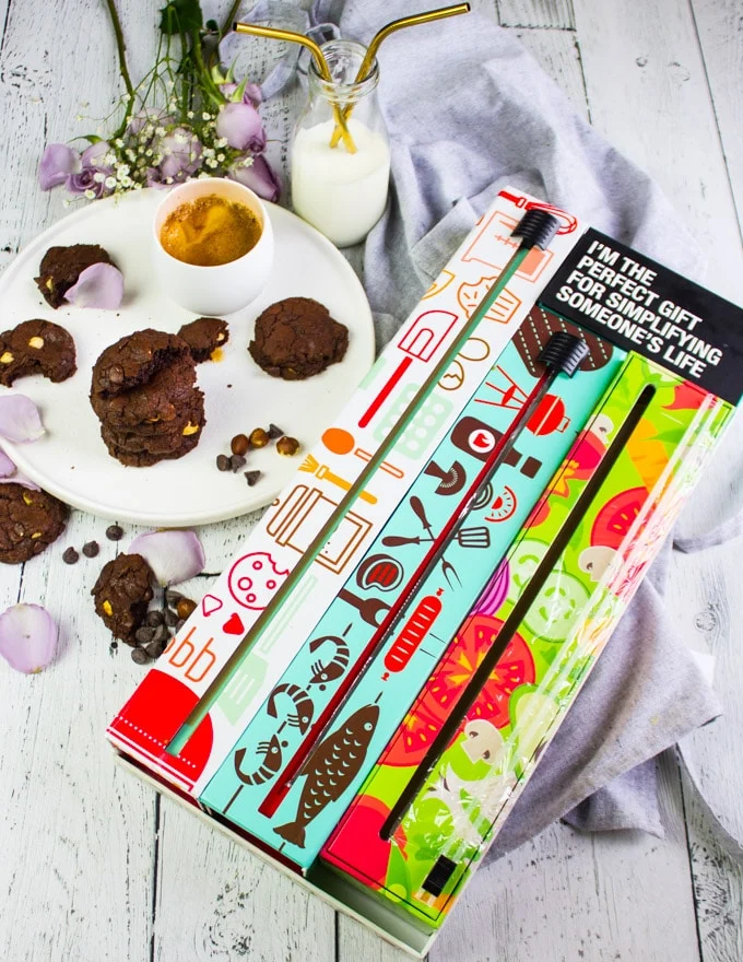 A three pack of dispensers and a plate of chocolate brownie cookies
