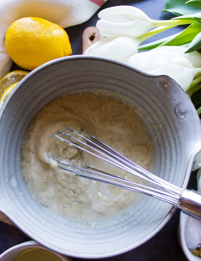 Water added to the tahini paste and it starts to break up and look crumbled