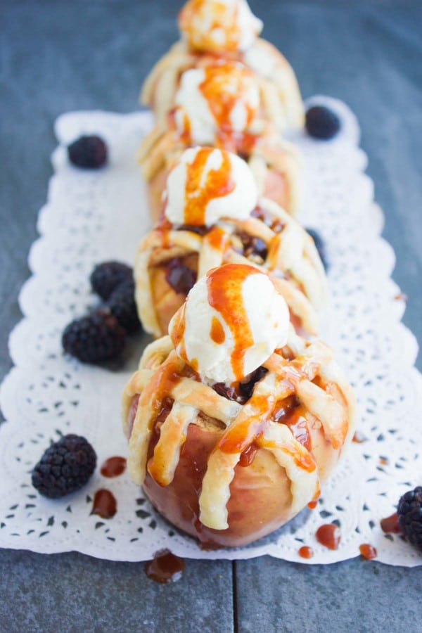 Apple Pie Stuffed Apples with golden brown pie crust lattice and a scoop of caramel drizzled ice cream on top