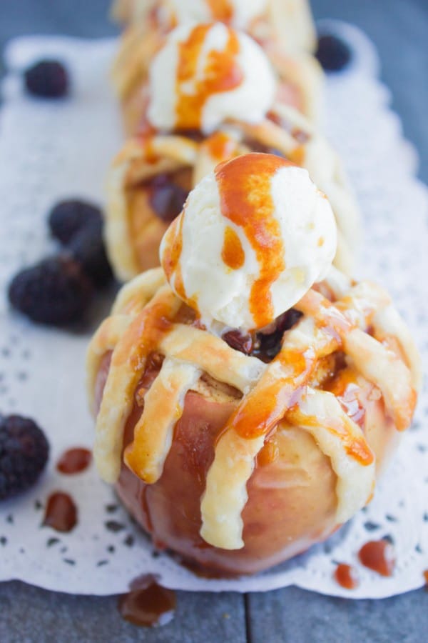Apple Pie Stuffed Apples with golden brown pie crust lattice and a scoop of caramel drizzled ice cream on top