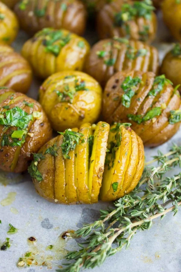 Close-up up Herb Roast Potatoes drizzled with butter and garnished with fresh thyme