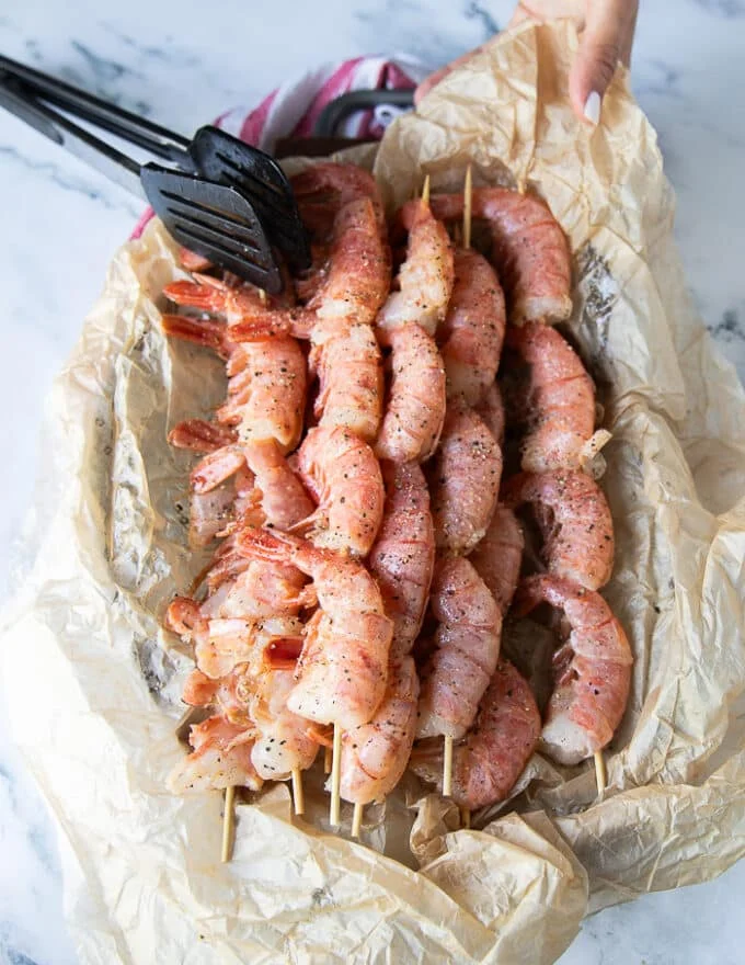raw shrimp skewered on wooden sewers for grilling