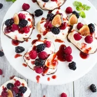 Chocolate Dipped Mini Pavlova. A 5 star delicate dessert shaped into mini hearts, dipped halfway in chocolate, topped with fresh whipped cream, berries and raspberry sauce. Get the recipe with step by step photos and tips to make the PERFECT pavlova every time! foodallianceblog.com