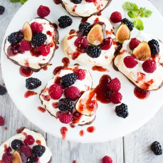 Chocolate Dipped Mini Pavlova. A 5 star delicate dessert shaped into mini hearts, dipped halfway in chocolate, topped with fresh whipped cream, berries and raspberry sauce. Get the recipe with step by step photos and tips to make the PERFECT pavlova every time! foodallianceblog.com