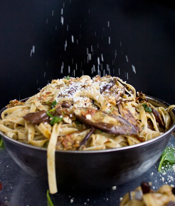 a bowl of Skinny Eggplant Parmesan Pasta being sprinkled with parmesan cheese