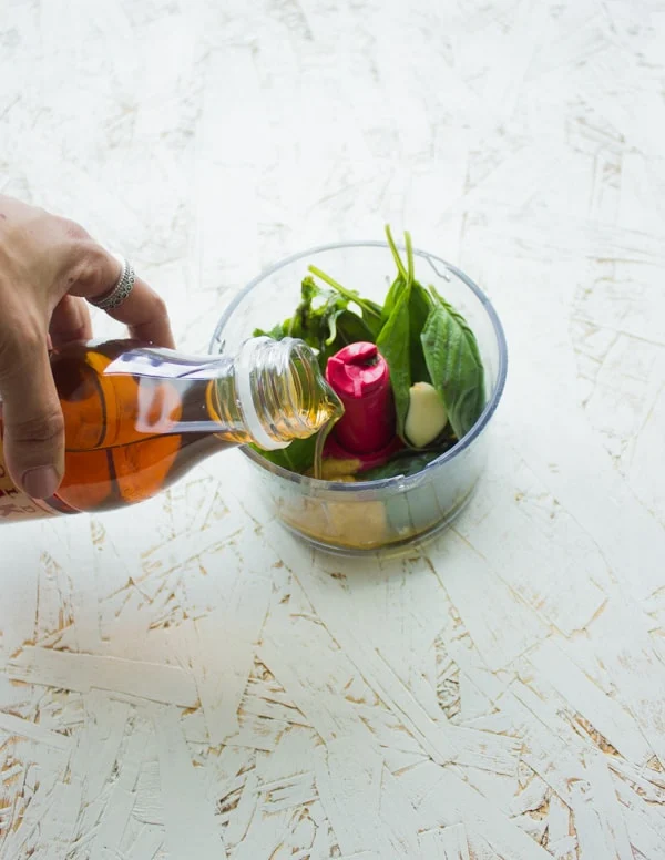 ingredients for a sweet tea dressing being added to a small food processor.