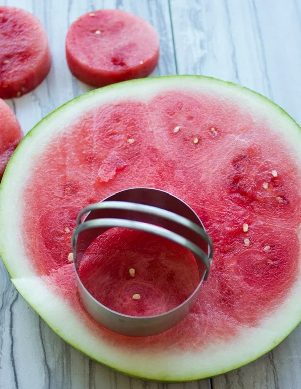 rounds being cut off a big slice of watermelon to make healthy ice cream cakes