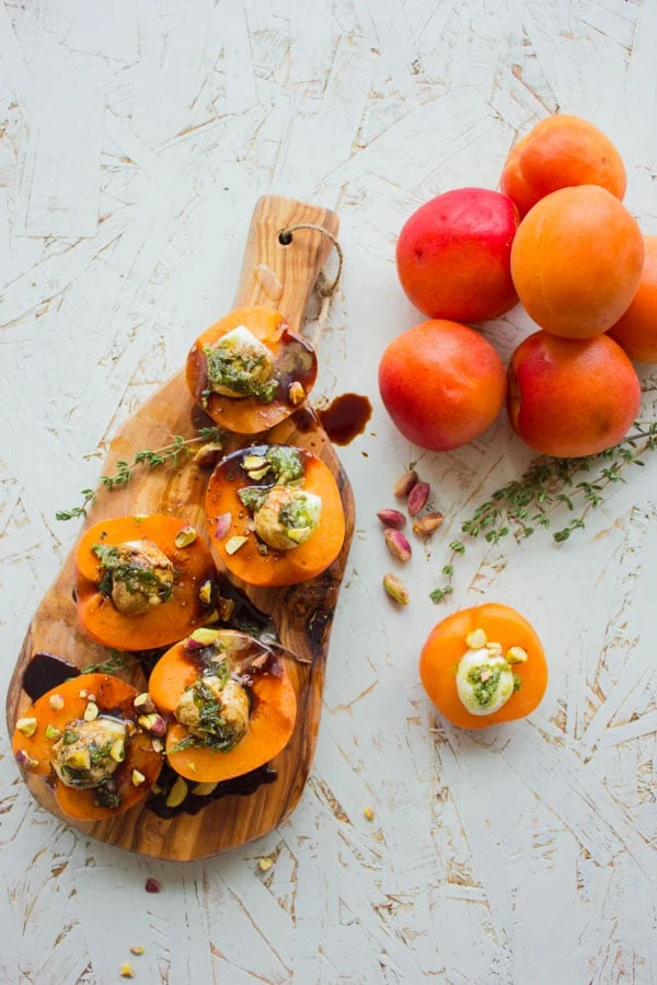 overhead shot of mozzarella stuffed apricots on a wooden board