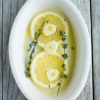 lemon and garlic slices on a white casserole dish