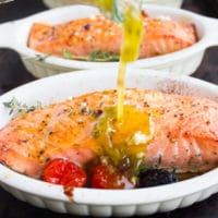 Freshly Baked Salmon Fillets being drizzled with Greek Dressing
