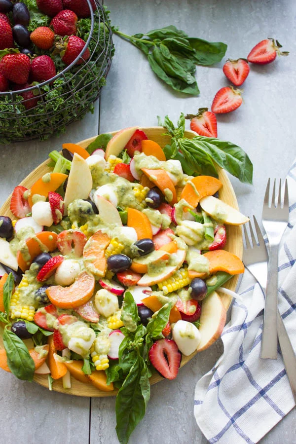 Summer Salad With Fruits & Basil. Swap your veggies, heavy dressings and bring on fruits, corn and some kale for a fresh BBQ salad favorite! Drizzled with a cream Basil Avocado Vegan dressing that you will use on anything and everything--not just the salad! Make this recipe today-foodallianceblog.com