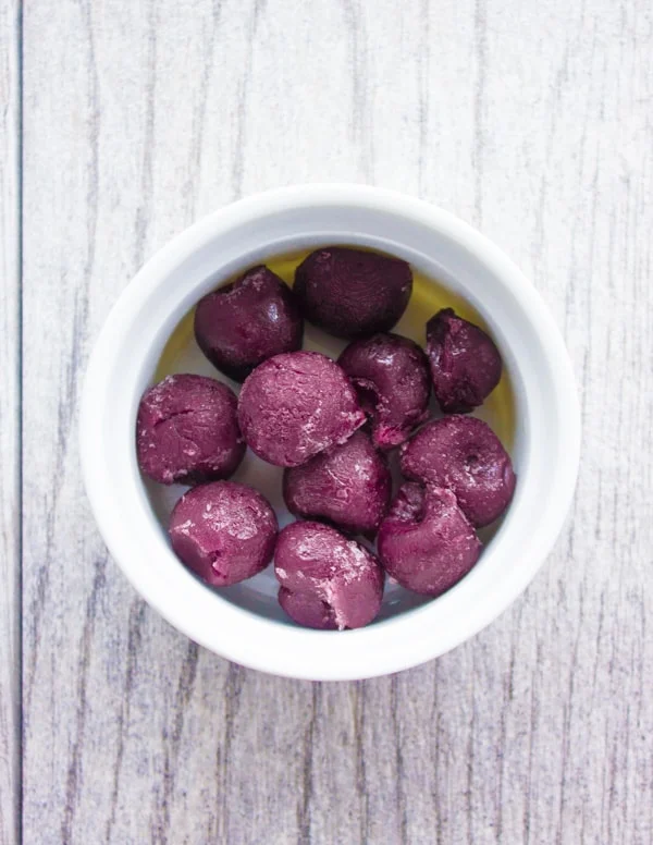 frozen cherries at the bottom of a small white ramekin