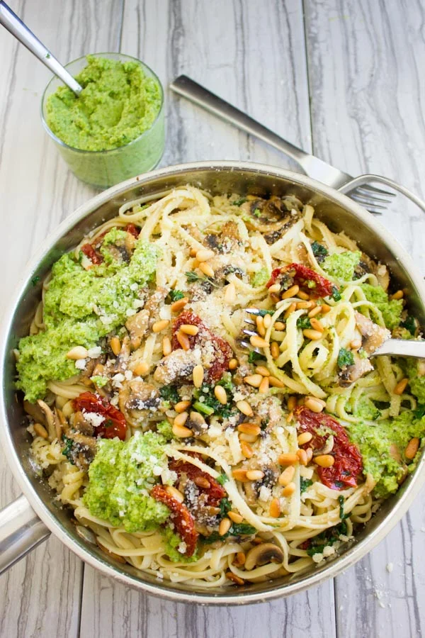 overhead shot of a skillet with fettuccine topped with Broccoli Pesto, parmesan and pine nuts
