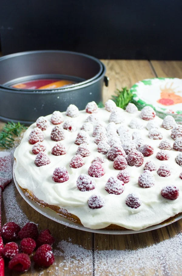 Fluffy White Raspberry Holiday Cake with vanilla whipped cream and fresh sugar-dusted raspberries