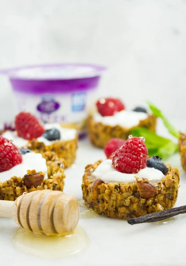 side view of healthy homemade Granola Cups filled with yogurt, berries and honey