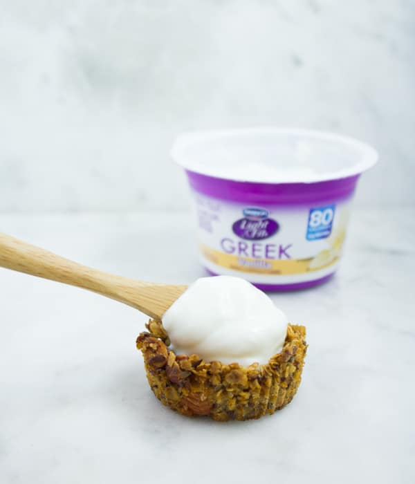 Greek Yogurt being spooned into homemade granola cups