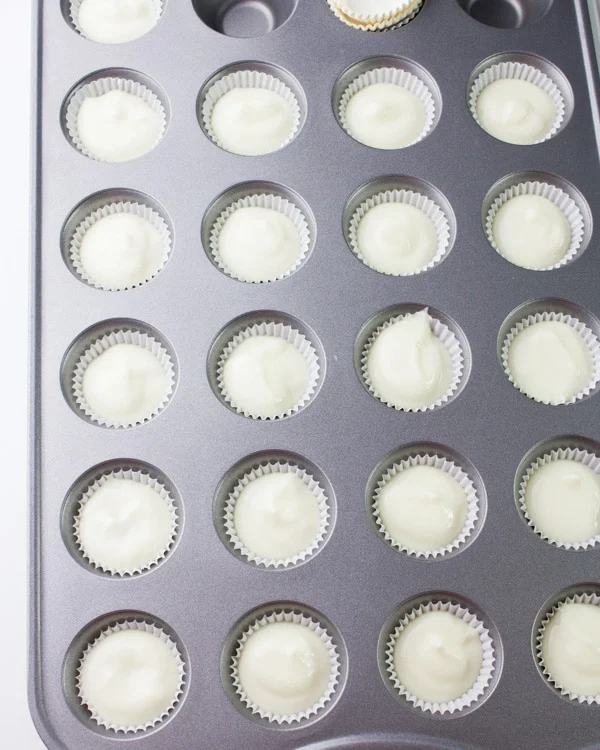 a muffin tin with Greek yogurt mini cheesecake bites ready to be baked