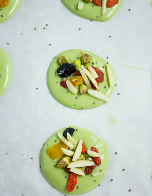 matcha white chocolate bark rounds topped with dried goji berries and nuts