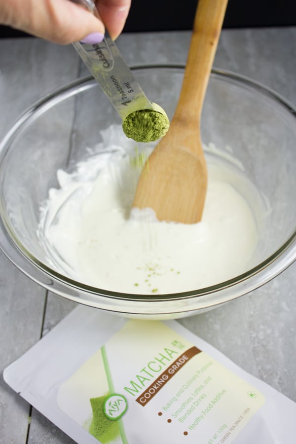 matcha green tea powder being added to melted white chocolate