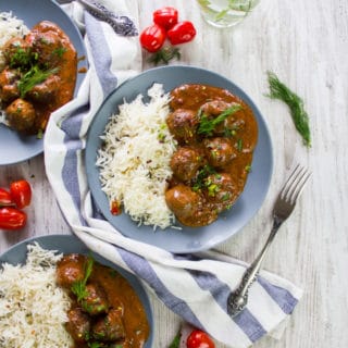 two plates of turkish meatballs in tomato sauce with a tea towel