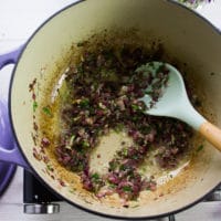 onions sauteed at the bottom of the pot with herbs showing them caramelized and ready to proceed