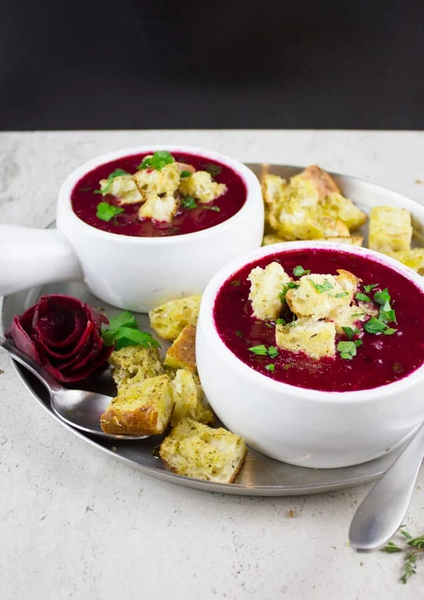 two bowls of Russian Beetroot Soup with croutons on top and on the side