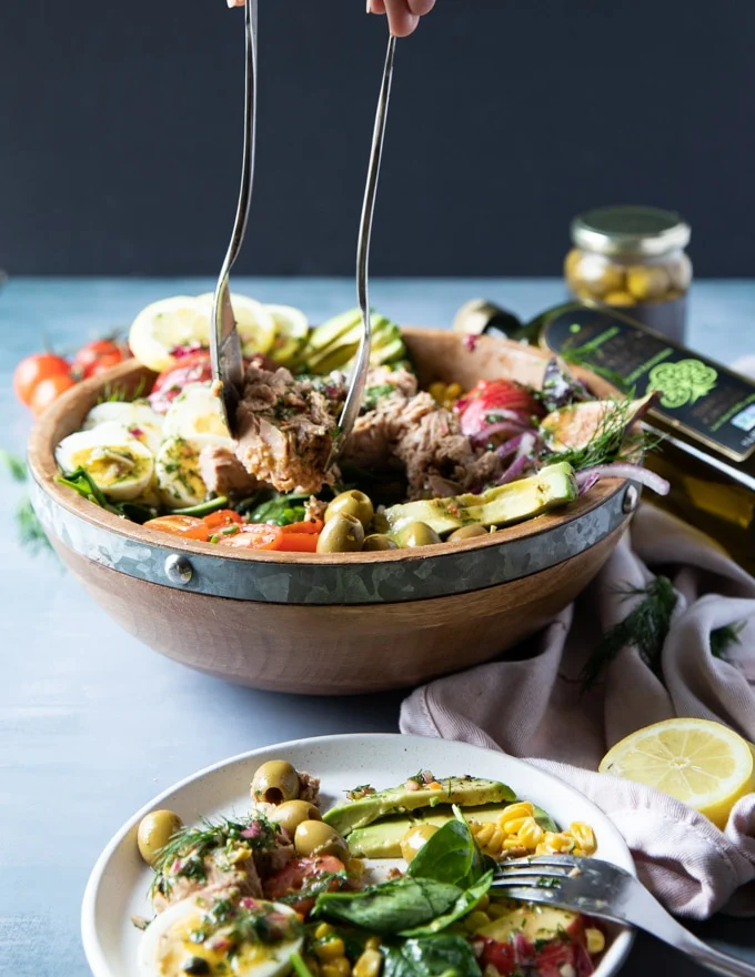 two salad serving spoons serving up a healthy tuna salad