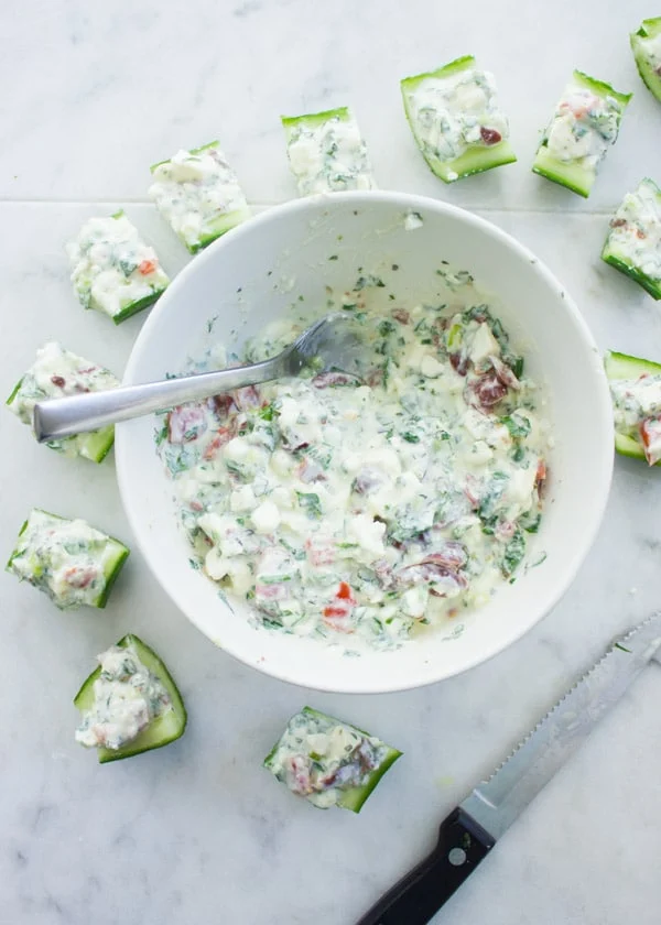 Overhead shot of Feta Cucumber Salad Bites arranged around a bowl with feta cream filling