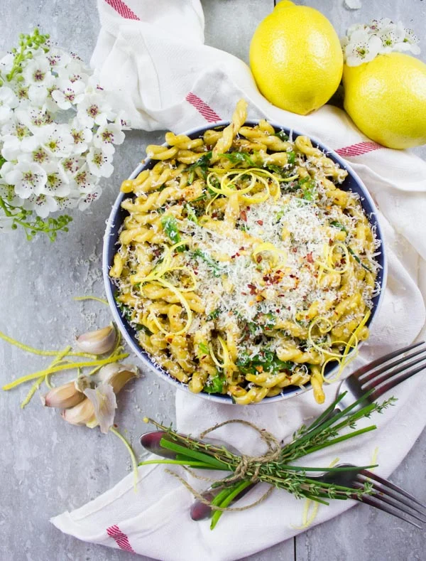 overhead shot of a bowl of Garlic Lemon Pasta sprinkled with parmesan cheese and lemon zest