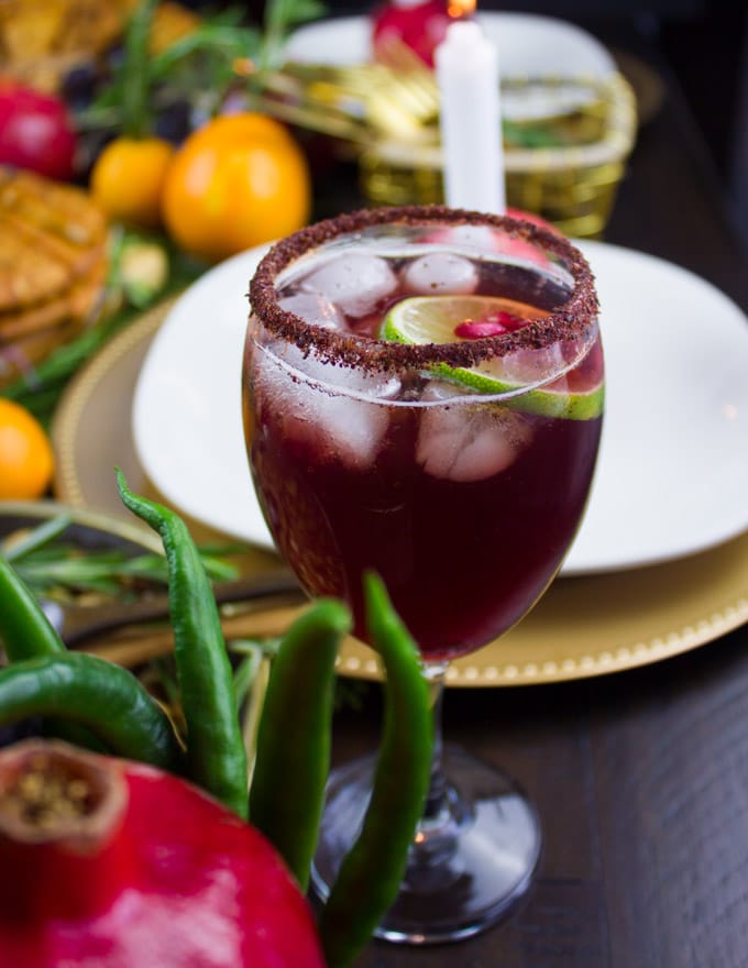 side-view of pomegranate mocktail with a lemon slice and pomegranate arils