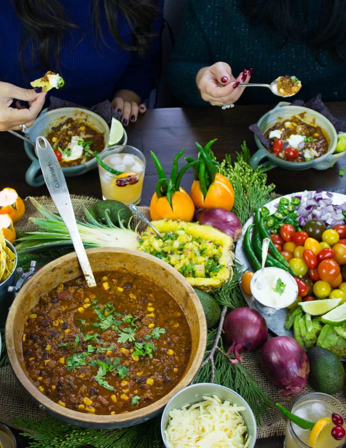 a chili party in full swing with guests eating and drinking cocktails