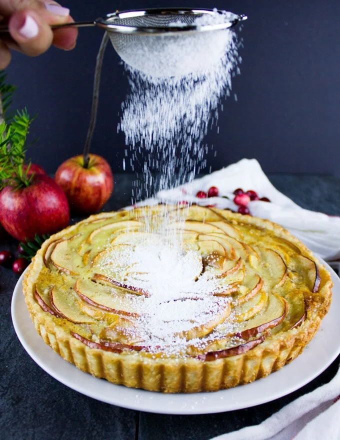 Swiss Apple Tart being dusted with icing sugar