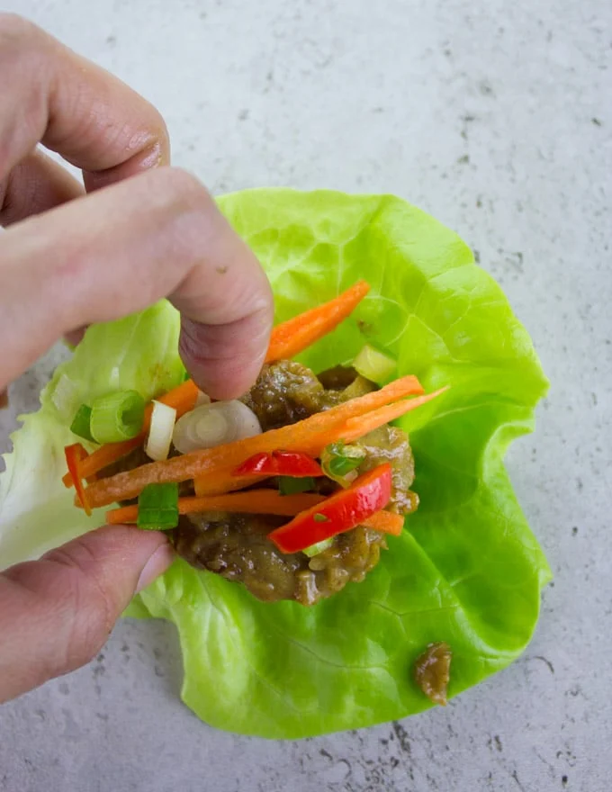 a Thai chicken meatball lettuce wrap being assembled