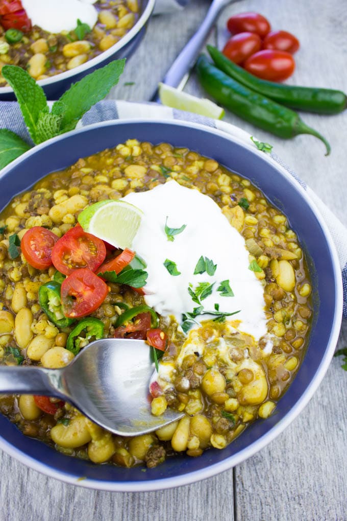 a spoon being dipped into a bowl of Moroccan Lamb and Lentil Soup