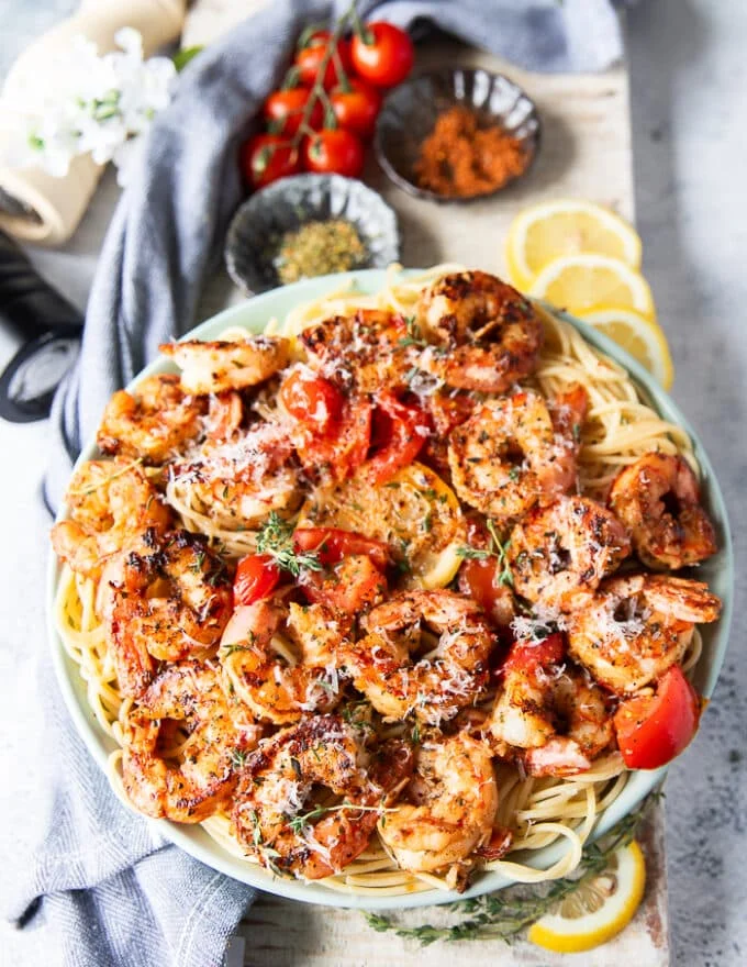 the finished plate of shrimp pasta garnished with herbs, chilli flakes, feta cheese and ready to enjoy