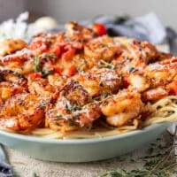 side view of shrimp pasta showing the layers of pasta and mediterranean style shrimp on top