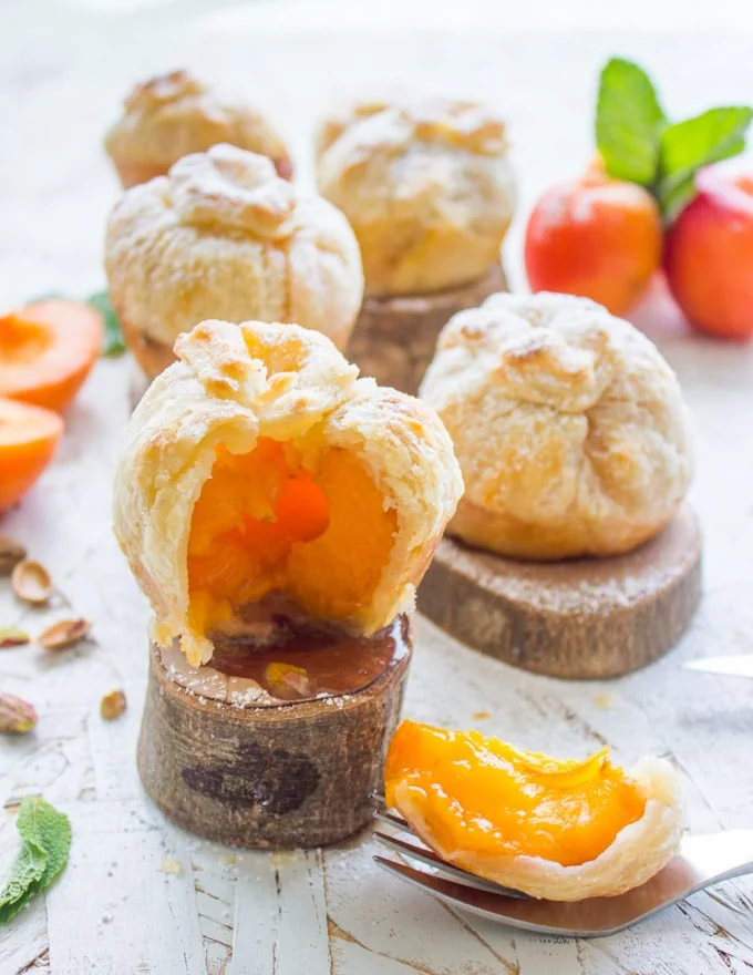 side view of a halved Whole Apricot Pie on a small wooden stand