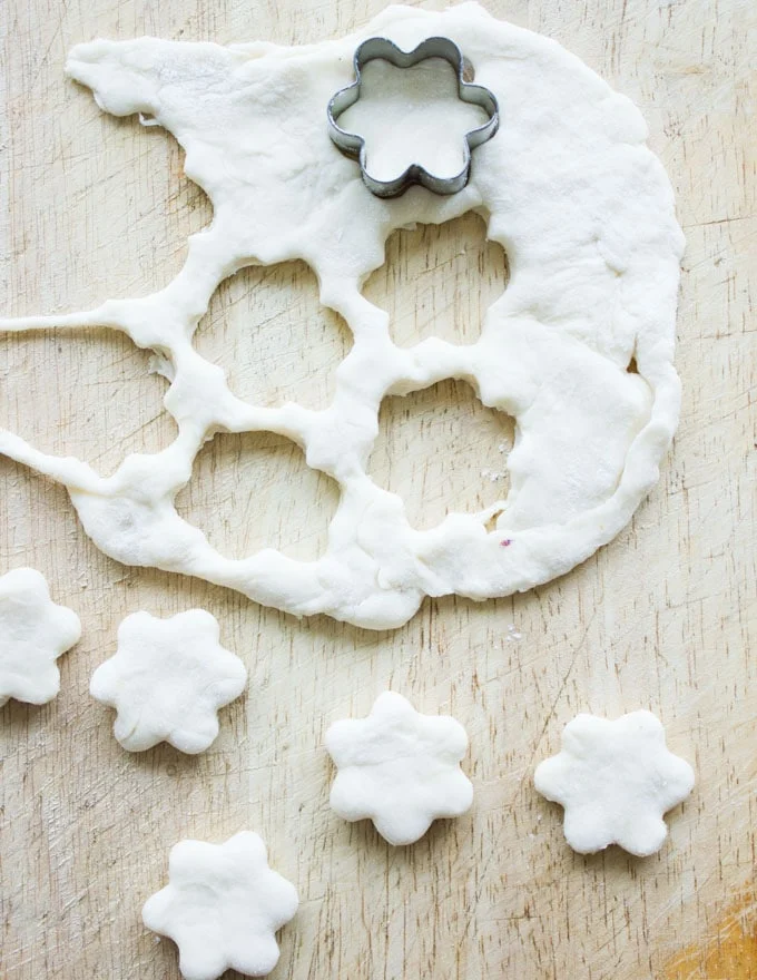 flours being cut off of rolled out pie pastry with a cookie cutter