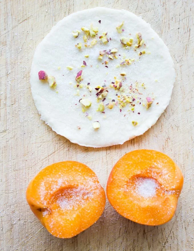 a pie pastry round being sprinkled with chopped pistachios