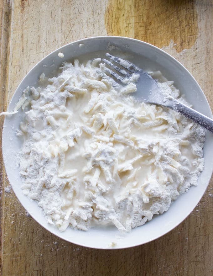 water being added to a bowl with dry pie crust ingredients
