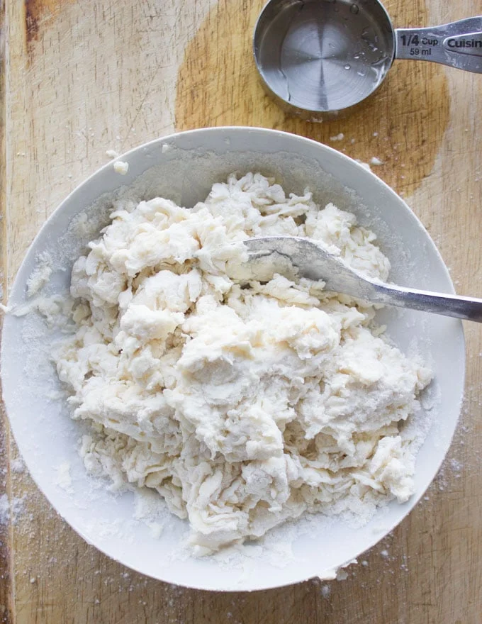 pie dough being stirred together with a fork