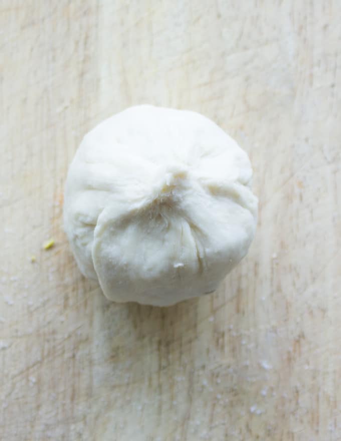 a whole apricot being wrapped into pie pastry