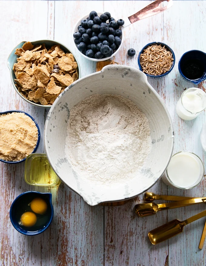 ingredients for the bran muffins including flour, baking powder, baking soda, bran, brown sugar, eggs, oil, vanilla, milk